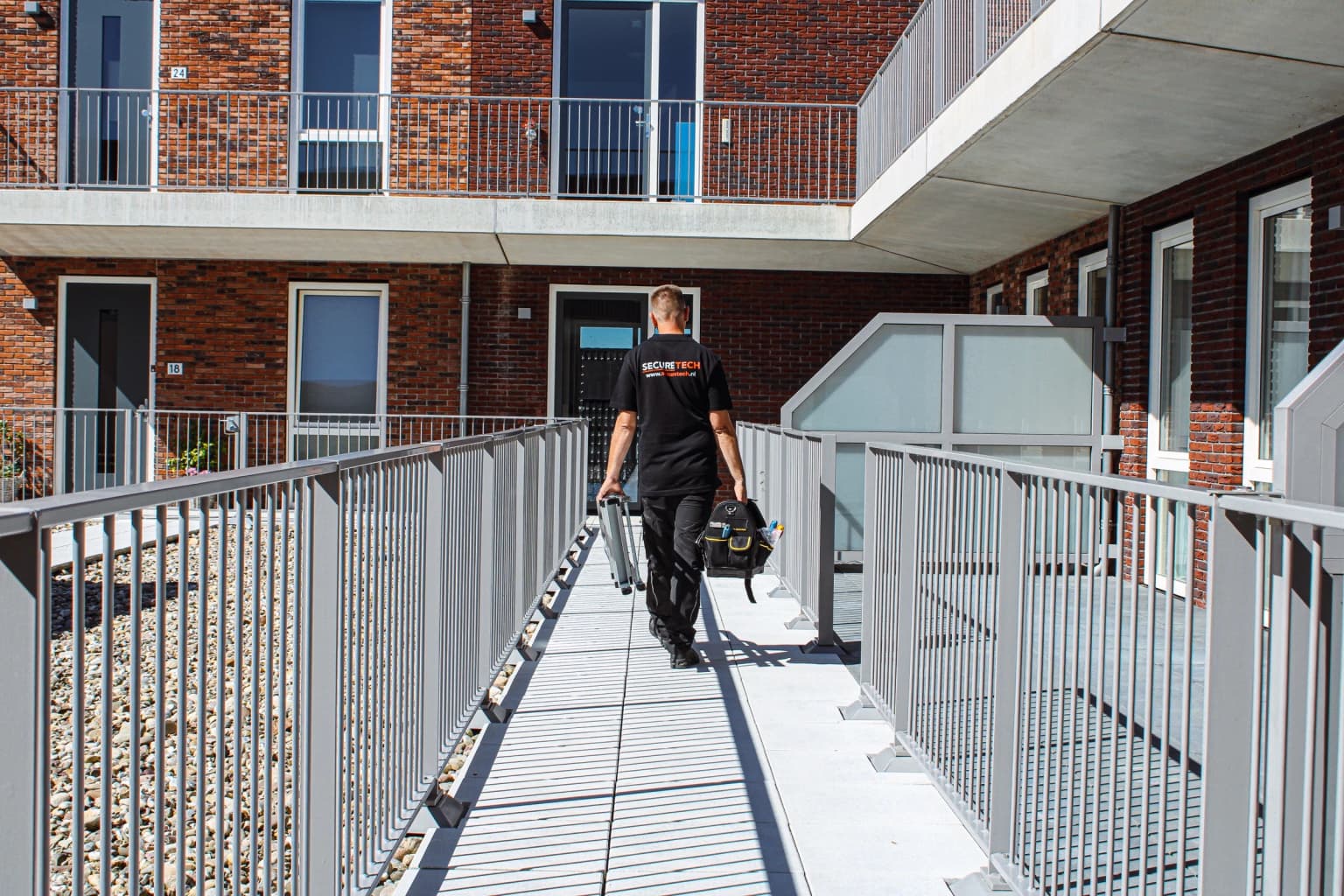 Securetech monteur onderweg naar een installatie met ladder en gereedschap